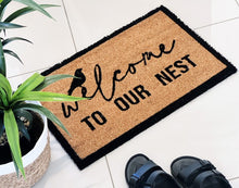 Load image into Gallery viewer, Our Welcome To Our Nest Door Mat is the perfect way to create a welcoming feel to your home before your guests even step foot inside with its beautiful design. Made from Natural coir fibres. PVC backing. Measures: 40x60x1.5cm.| Bliss Gifts & Homewares | Unit 8, 259 Princes Hwy Ulladulla | South Coast NSW | Online Retail Gift & Homeware Shopping | 0427795959, 44541523